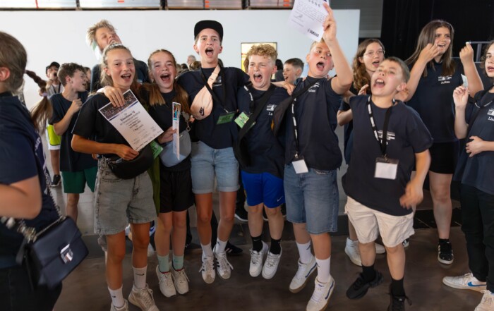 Jubelnde Schüler:innen der Bläserklasse 7d direkt nach der Siegerehrung – mit Urkunden in den Händen und breitem Lachen im Gesicht feiern sie ihren ersten Platz beim BW Musix-Wettbewerb.