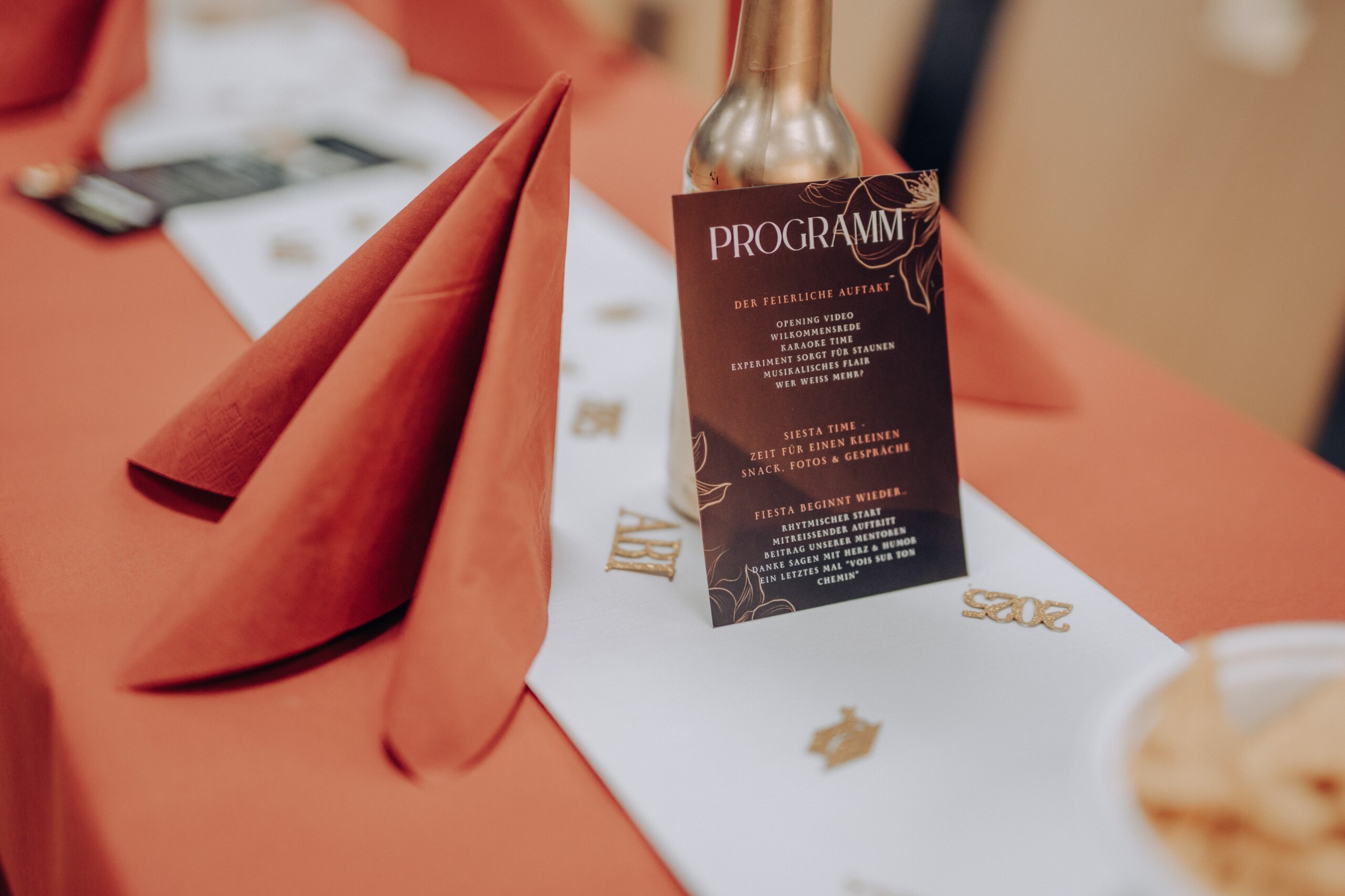 Detailaufnahme eines festlich gedeckten Tisches mit Programmkarte des Abiballs: „Der feierliche Auftakt“, „Siesta Time“ und „Fiesta beginnt wieder“ stehen als Überschriften auf der Menükarte.