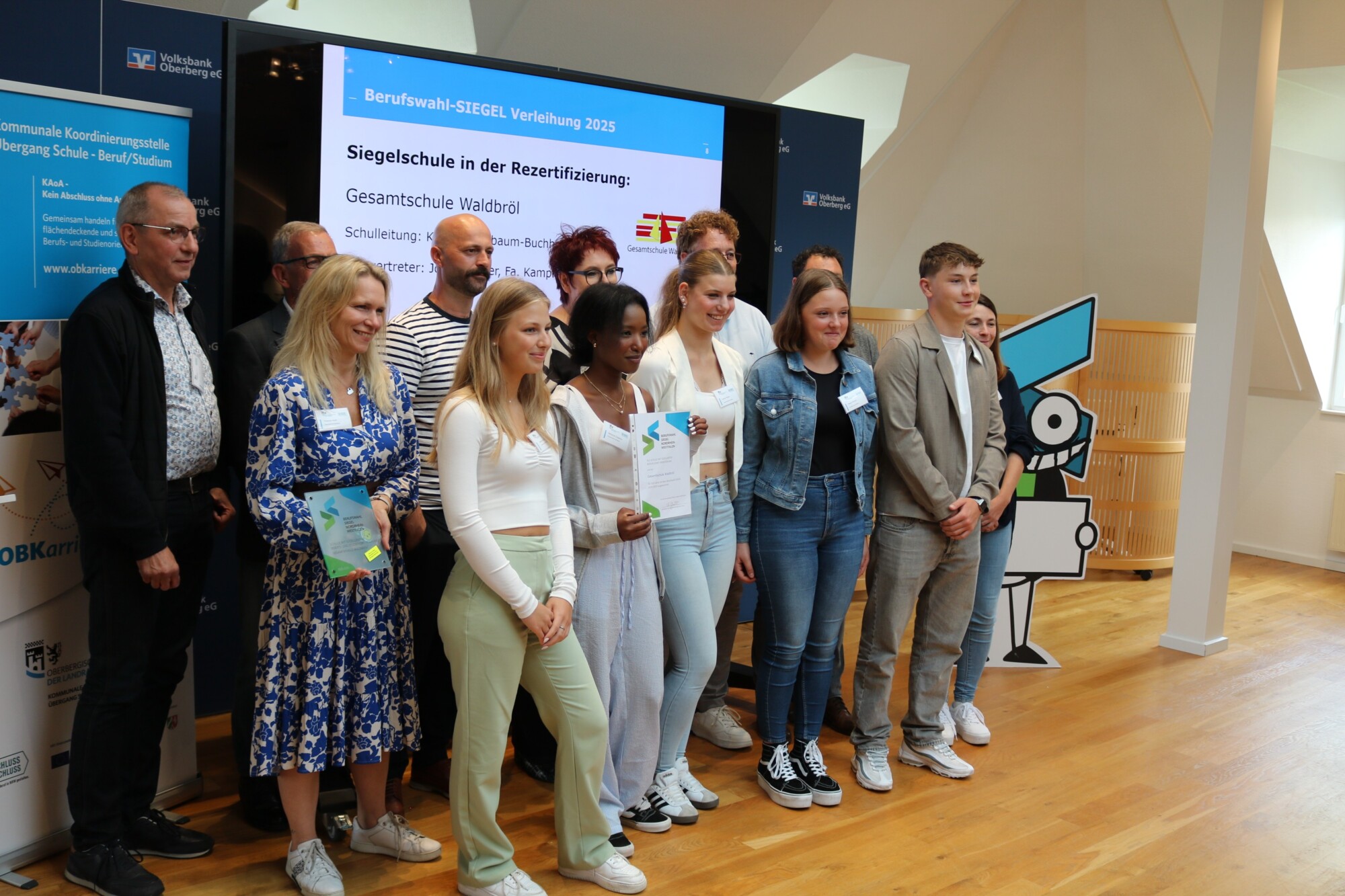 Gruppenfoto der Delegation der Gesamtschule Waldbröl nach der Siegelverleihung 2025. Schüler:innen und Lehrkräfte halten die Urkunde und das Siegel-Emblem in den Händen.