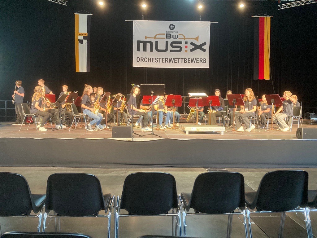 Die Bläserklasse 7d während ihres Auftritts auf der großen Bühne der Volksbankmesse Balingen – konzentriert, synchronisiert und mit gespannter Aufmerksamkeit vor dem Wettbewerbspublikum.