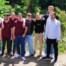 Gruppenfoto beider Teams der Gesamtschule Waldbröl vor grüner Kulisse im Schlosspark Eller: Die Jugendlichen stehen entspannt nebeneinander, einige mit verschränkten Armen, andere mit lachendem Blick zur Kamera.