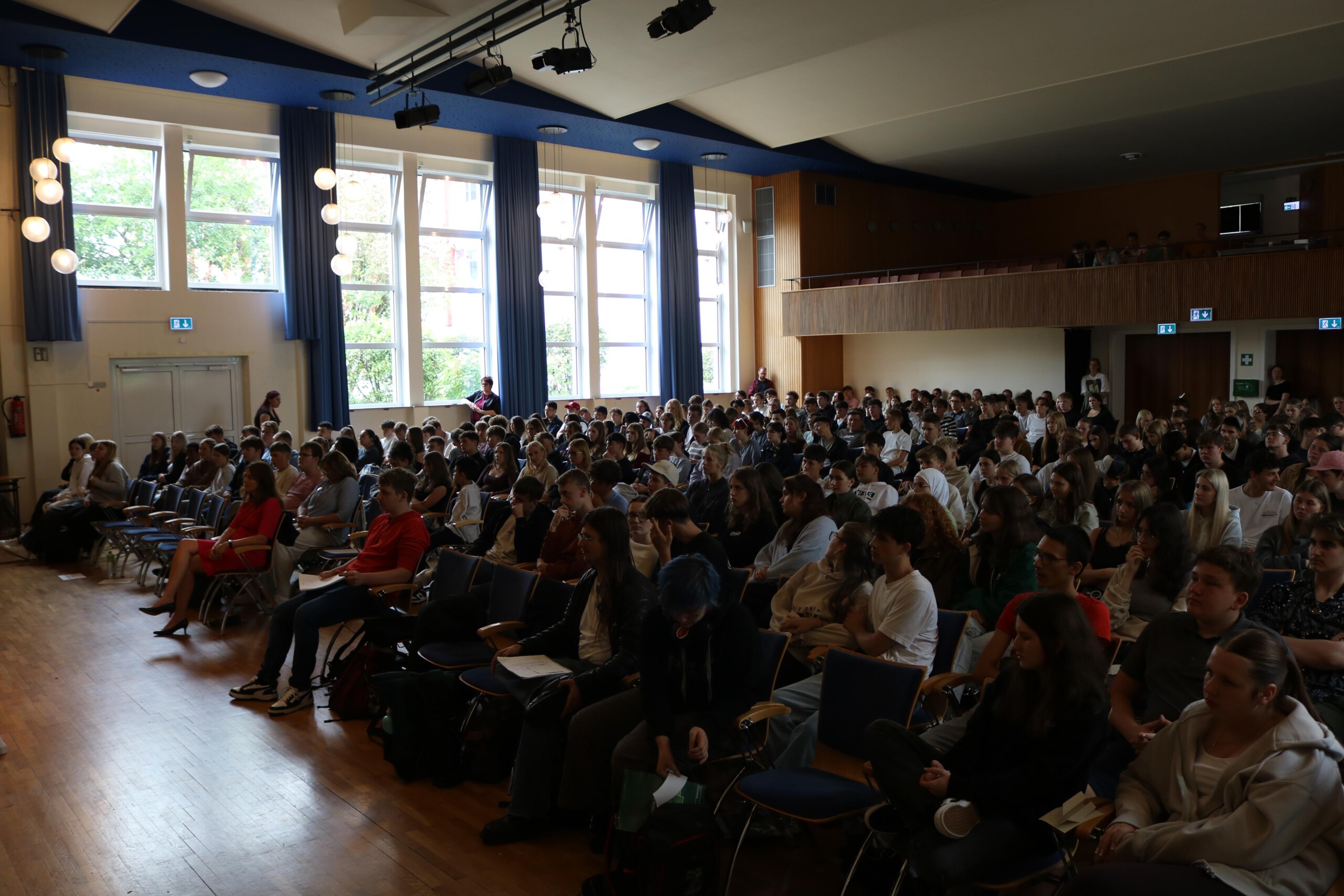 Rund 350 Schüler:innen der Jahrgangsstufe 10 sowie der Oberstufe verfolgen aufmerksam die Podiumsdiskussion.