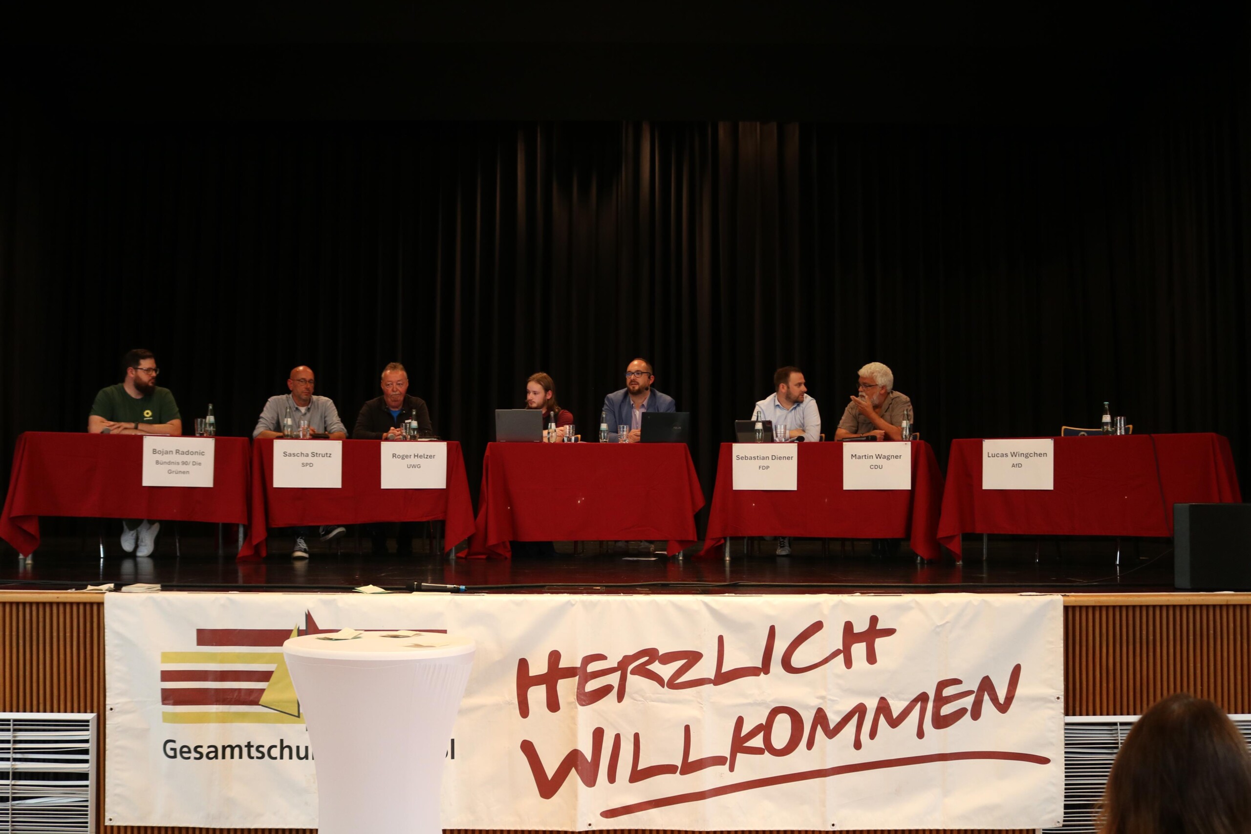 Die Podiumsrunde mit Vertreter:innen der im Stadtrat kandidierenden Parteien, der Platz für die AfD blieb leer.