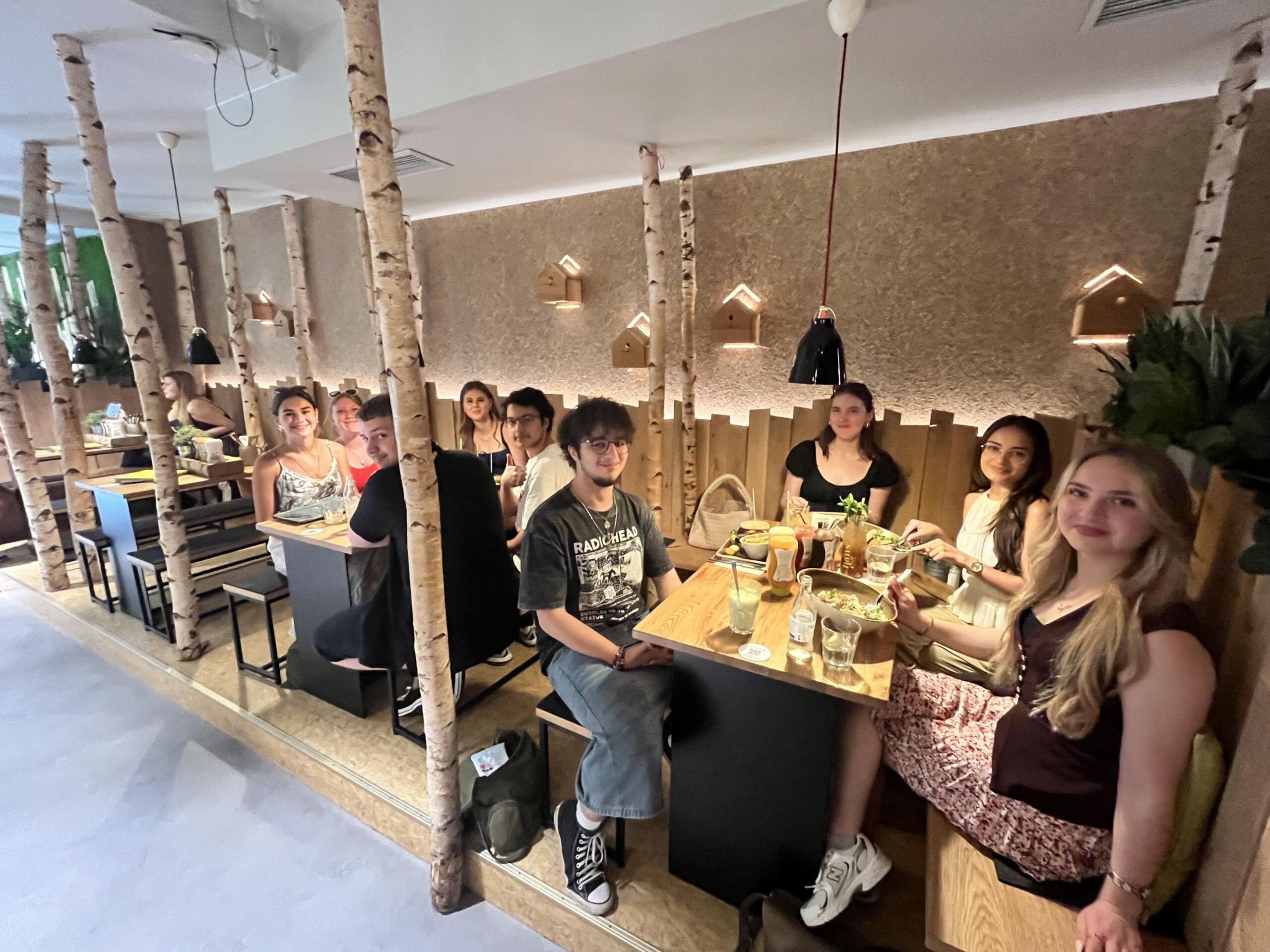 Die Schüler:innen des Cambridge-Projektkurses sitzen nach der Prüfung in einem Restaurant zusammen und feiern den erfolgreichen Abschluss.