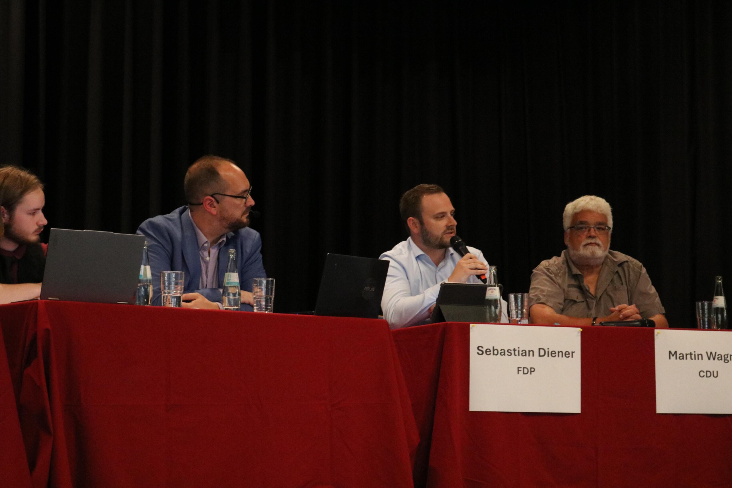 Sebastian Diener (FDP) und Martin Wagner (CDU) im Gespräch, begleitet von Moderator Andreas Dohm.