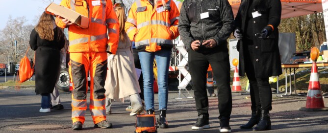 Mehrere Aussteller:innen präsentieren sich im Außenbereich der Messe. Arbeitskleidung, Geräte und Fahrzeuge machen handwerkliche Berufe sichtbar und greifbar.