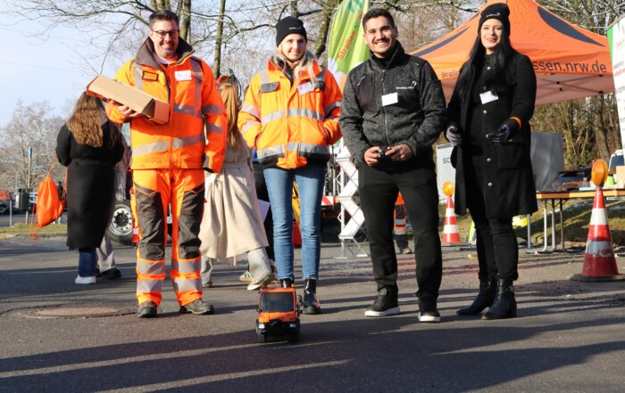 Mehrere Aussteller:innen präsentieren sich im Außenbereich der Messe. Arbeitskleidung, Geräte und Fahrzeuge machen handwerkliche Berufe sichtbar und greifbar.