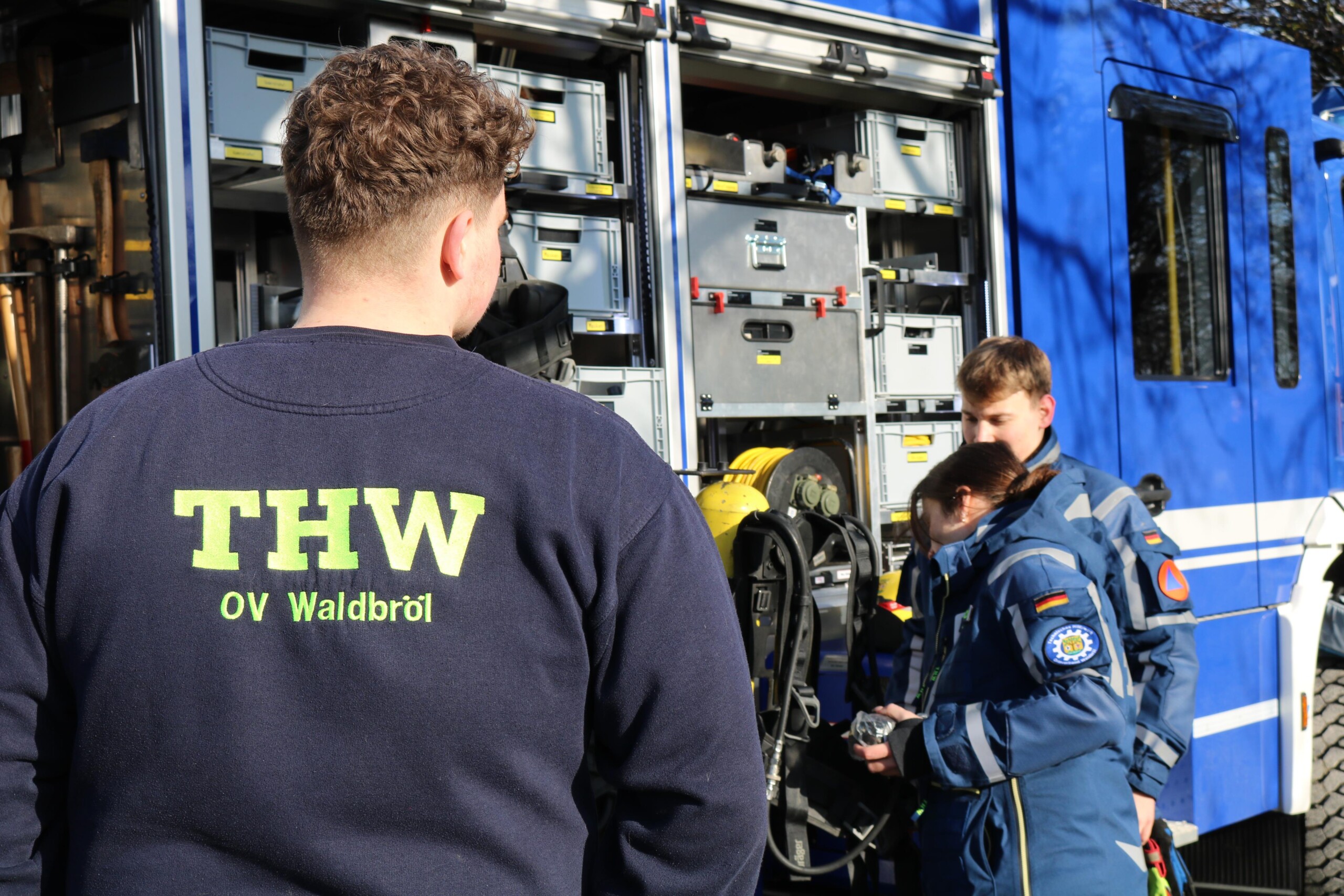 Jugendliche informieren sich am Einsatzfahrzeug des Technischen Hilfswerks über Ausstattung und Aufgabenfelder. Die Szene vermittelt Neugier und unmittelbare Nähe zur Praxis.