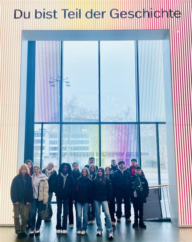 Gruppe von Schüler:innen der 10. Klassen der Gesamtschule Waldbröl vor der Installation mit der Aufschrift ‚Du bist Teil der Geschichte‘ im Haus der Geschichte in Bonn.