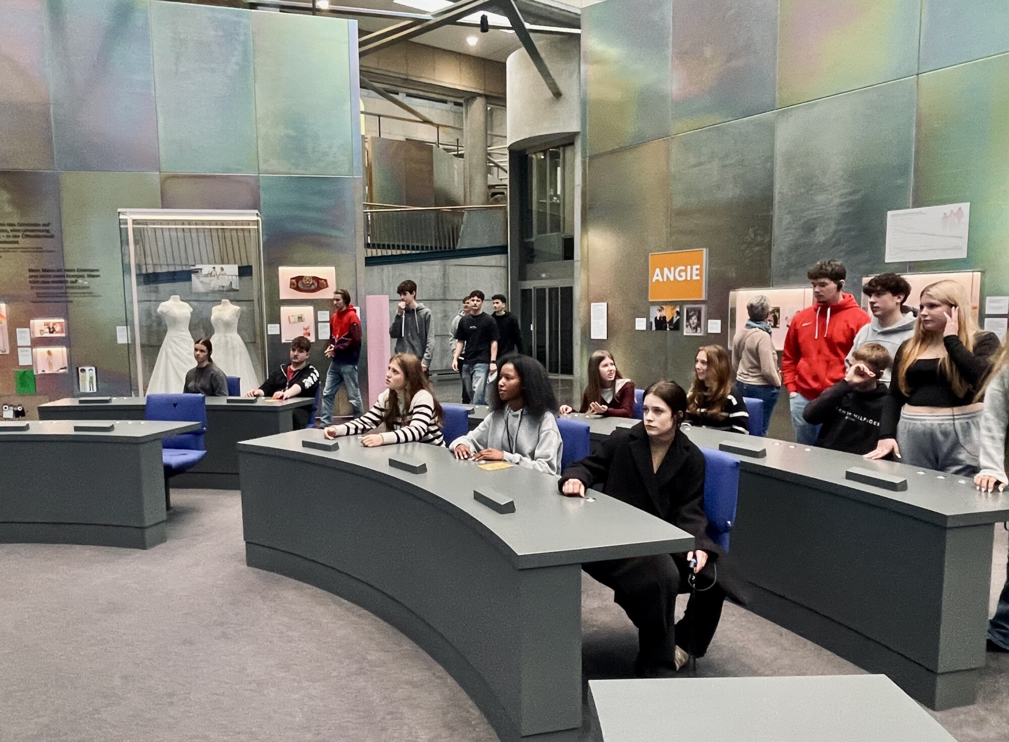 Schüler:innen der 10. Klassen der Gesamtschule Waldbröl nehmen im nachgebildeten Plenarsaal des ehemaligen Bundestages im Haus der Geschichte Platz und erleben eine Probeabstimmung.