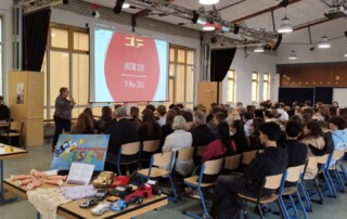Volle Mensa beim Infoabend: Schüler:innen und Eltern verfolgen die Einführung zur Kurswahl vor einer Präsentation.